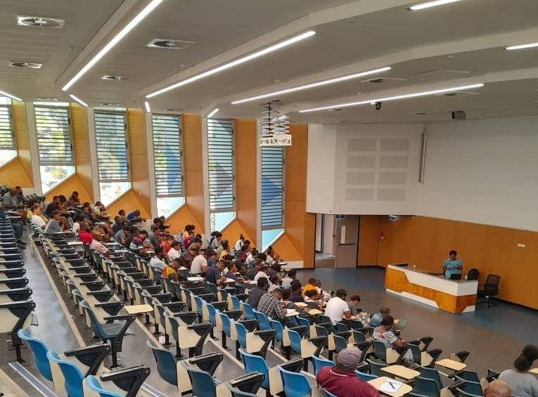 Students sitting inside auditorium.